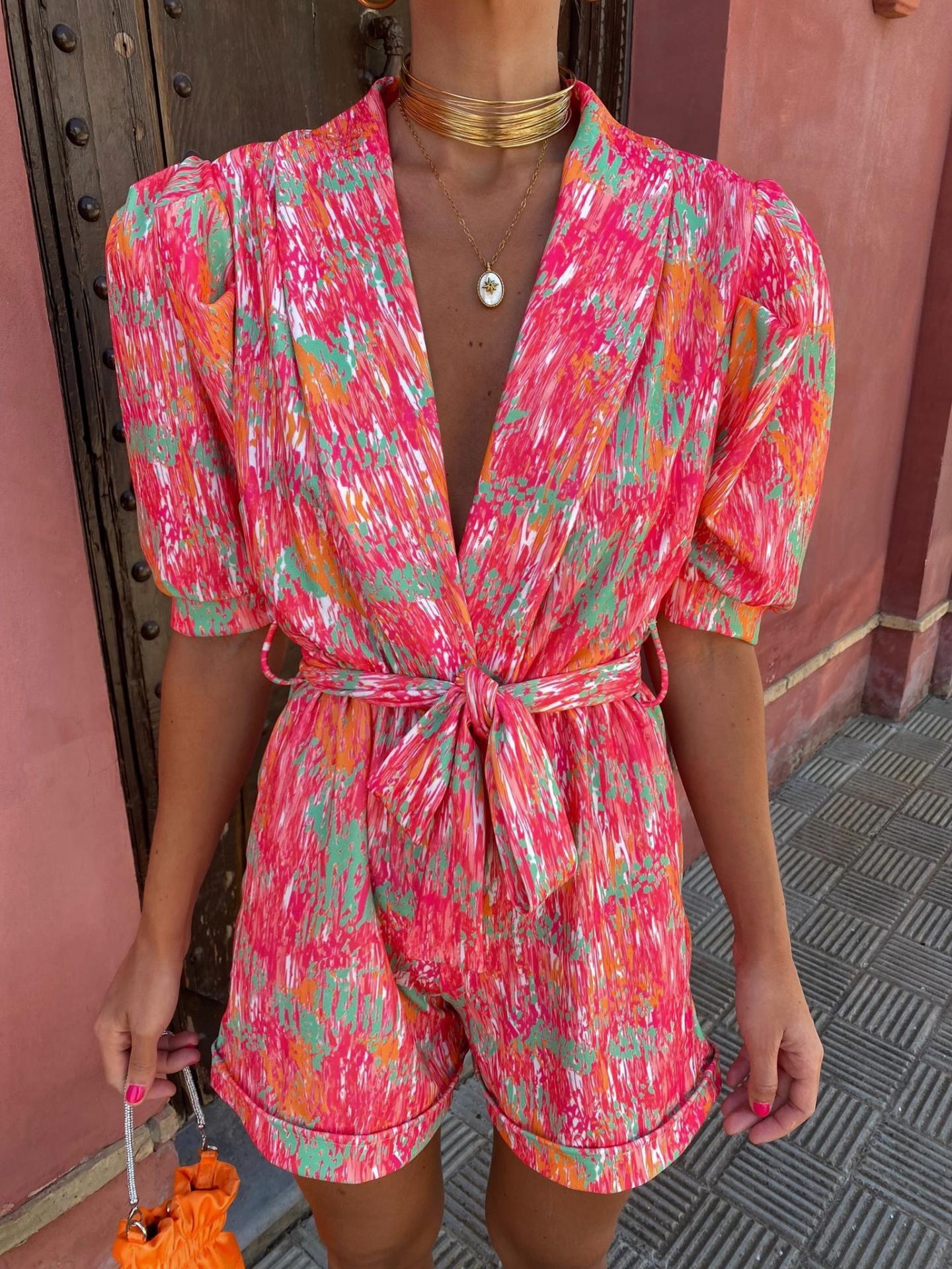 Front view of pink abstract print wrap romper with V-neckline
