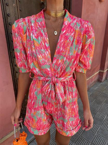 Front view of pink abstract print wrap romper with V-neckline