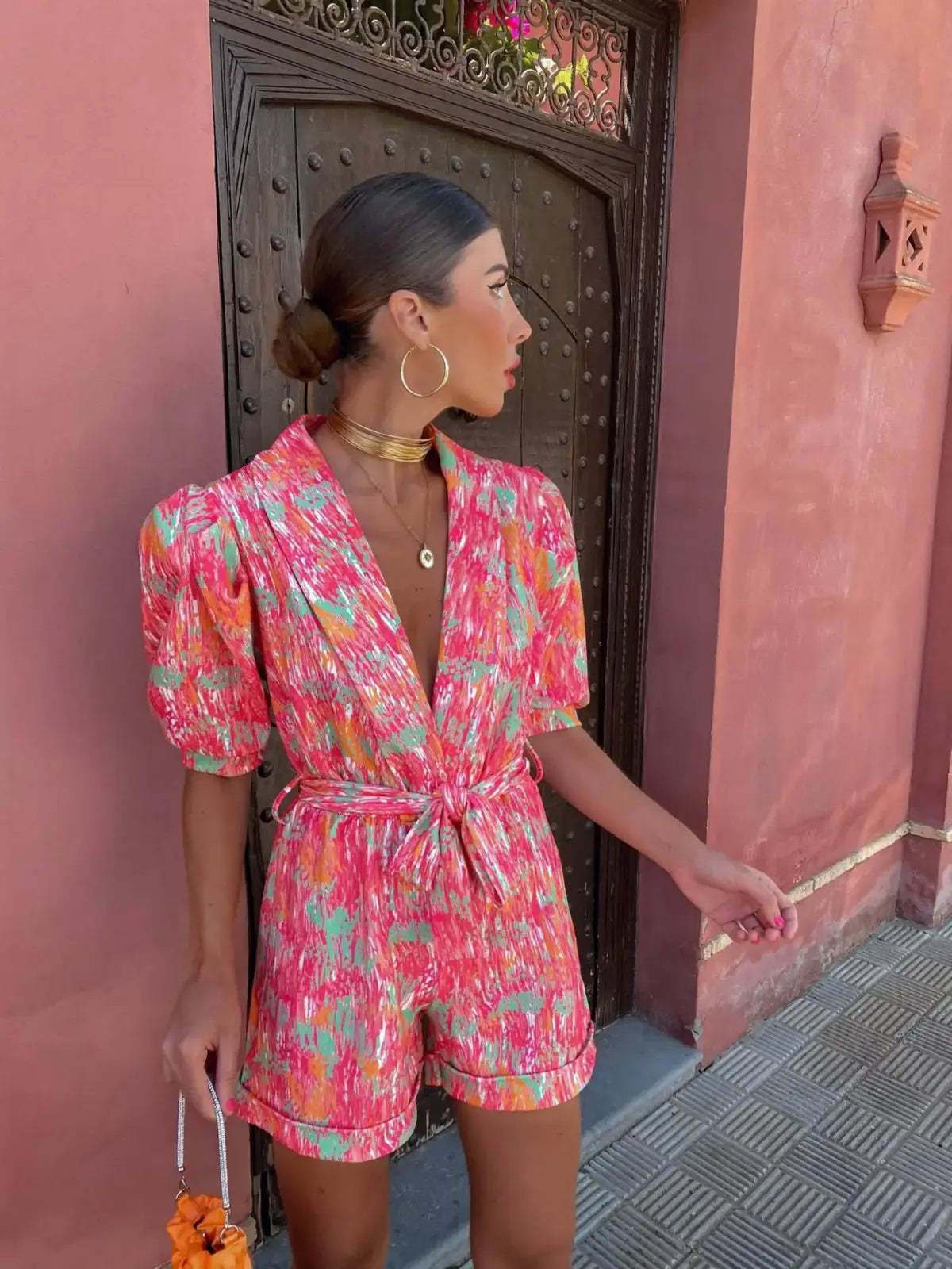 Side profile of pink wrap mini romper with short puffed sleeves