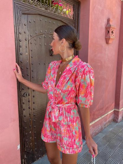 Back view of pink wrap romper showing tie closure and shorts length