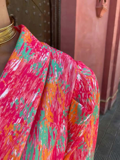Close-up of crinkle texture and multicolor print on pink romper fabric