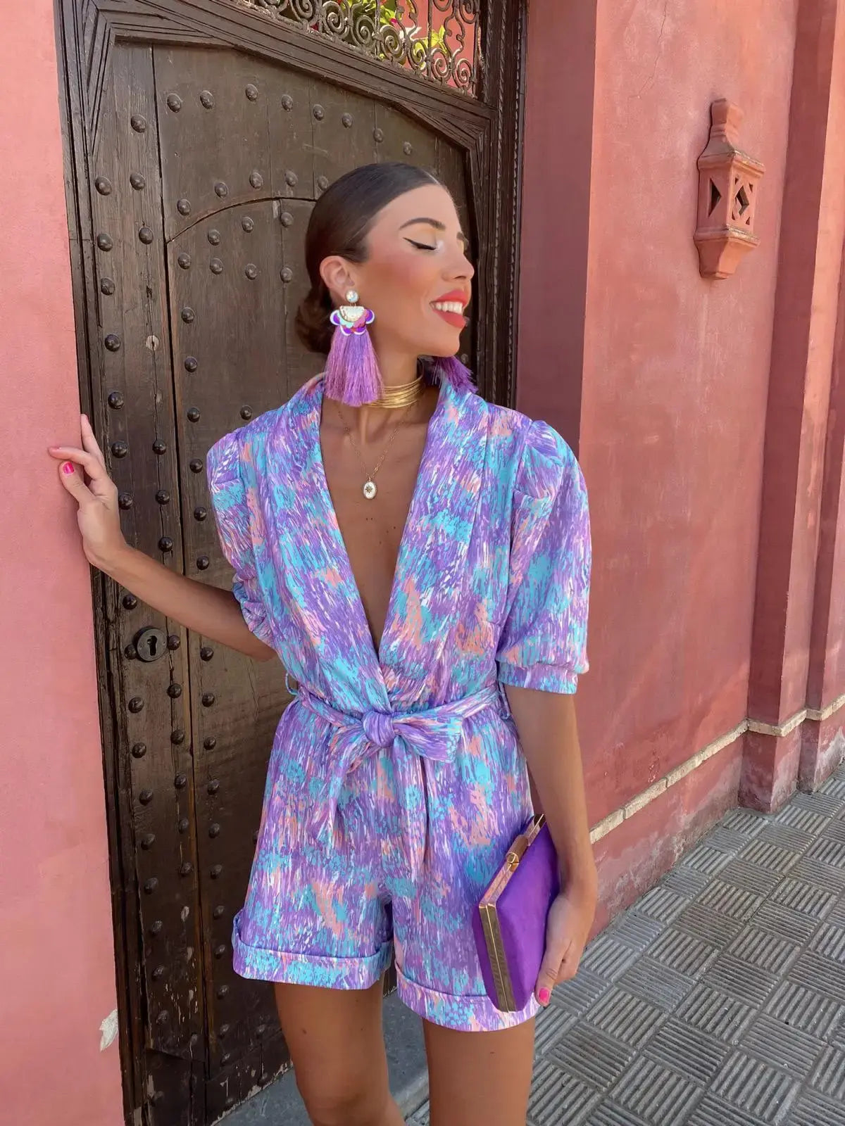 Front view of purple wrap romper with V-neckline and short sleeves
