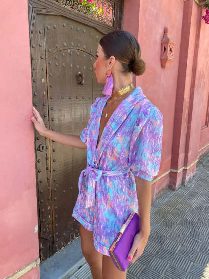 Side view of purple wrap mini romper with crinkle texture and shorts cut