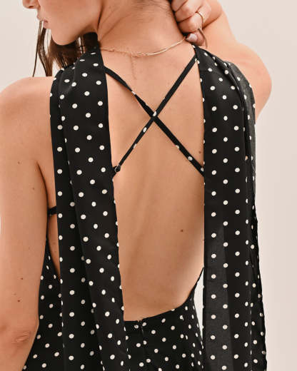 Close-up of backless maxi dress showing crossed tie straps and polka dot pattern detail