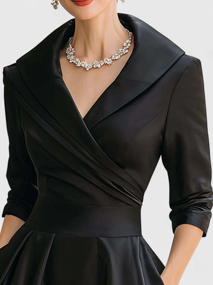 Close-up of black wrap midi dress neckline with notch collar detail