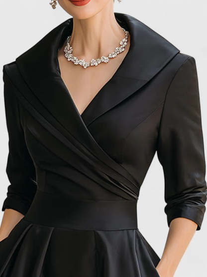 Close-up of black wrap midi dress neckline with notch collar detail
