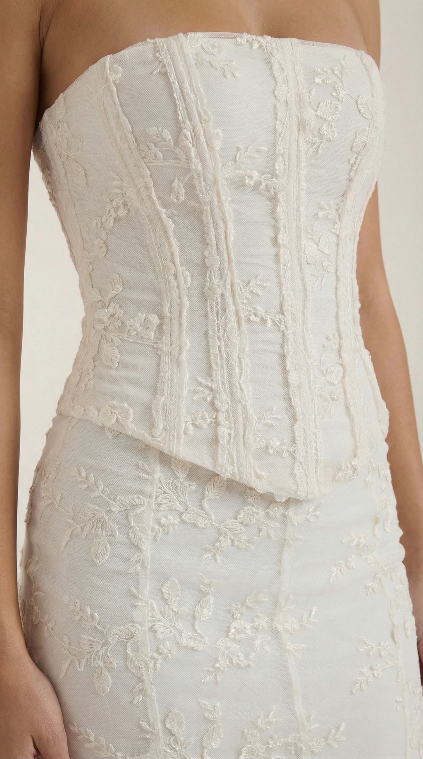 Close-up of structured corset bodice with dimensional floral lace and boning detail