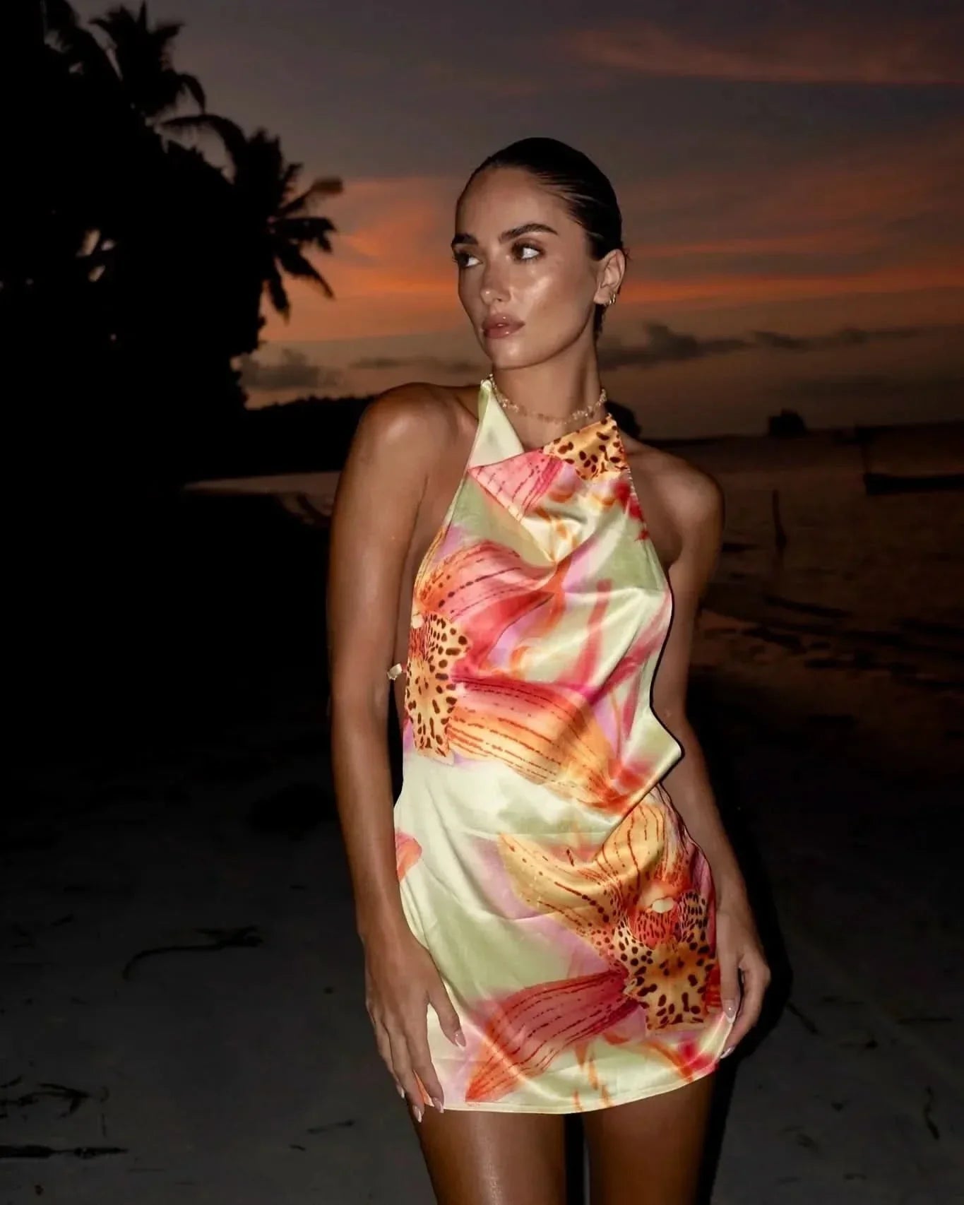Cream floral halter mini dress with draped neckline on woman at sunset