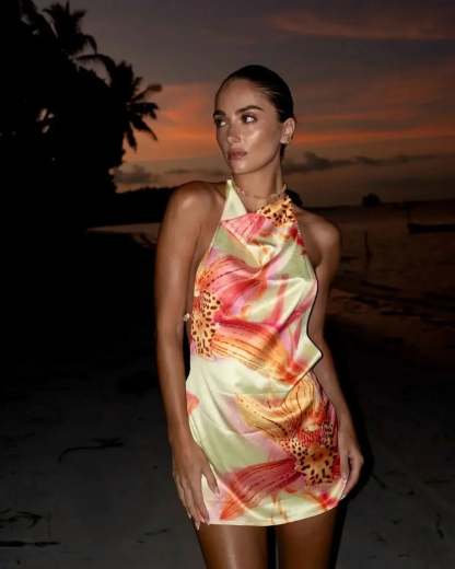 Cream floral halter mini dress with draped neckline on woman at sunset