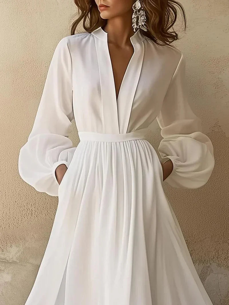 Close-up of V-neck and high waist pleating detail on ivory maxi dress