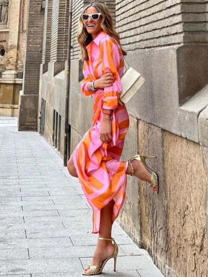 Side view of pink and orange striped wrap midi dress with asymmetrical ruched skirt