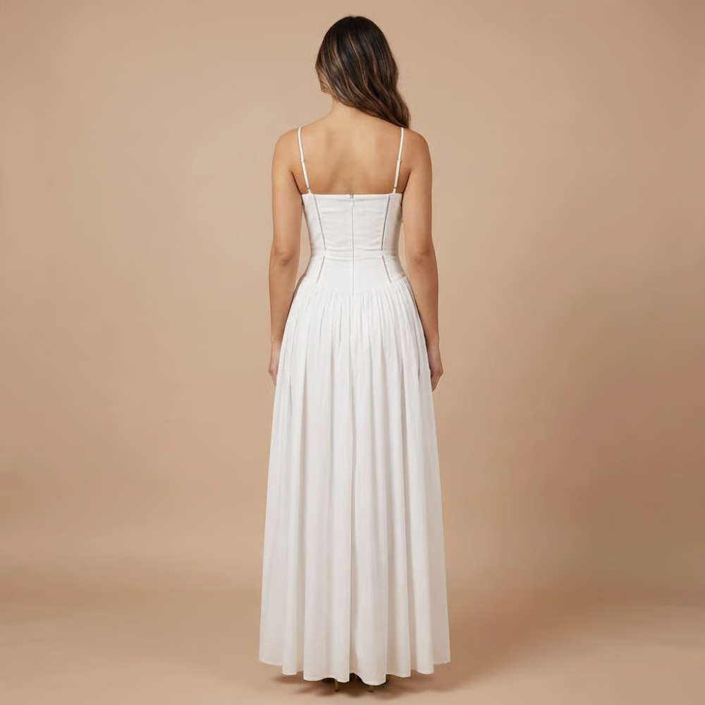 Back view of white corset midi dress with thin straps and flowing skirt