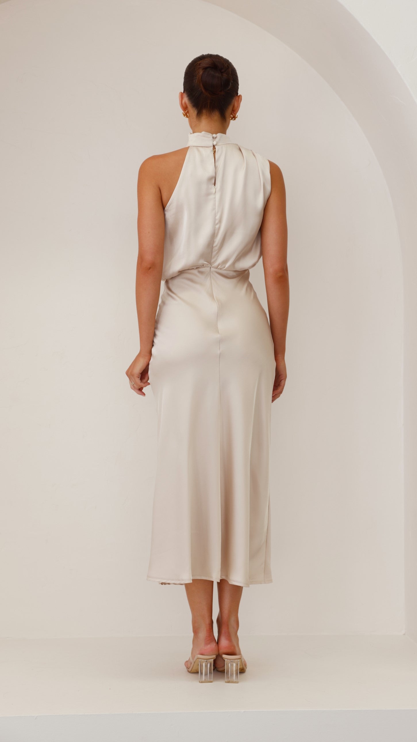 Back view of cream midi dress showing center seam and halter neckline closure