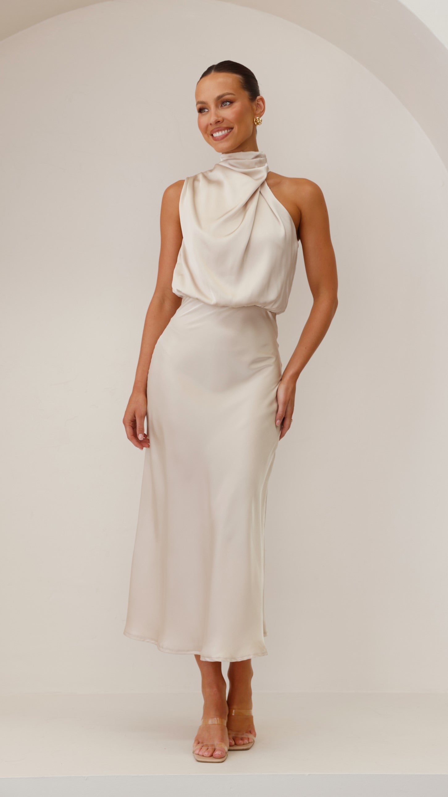 Cream draped halter midi dress with flowing neckline and fitted waist