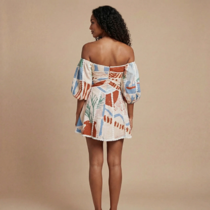 Back view of cream printed off-shoulder mini dress with back zipper and lace trim detail