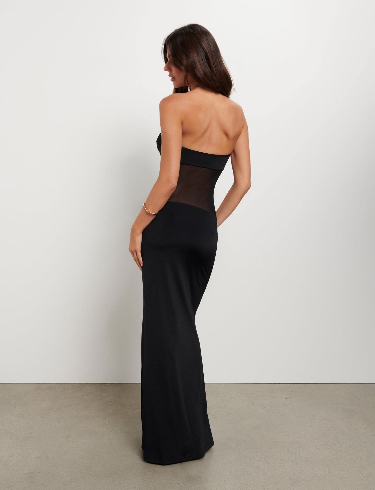 Back view of black maxi dress with strapless cut and sheer mesh panel