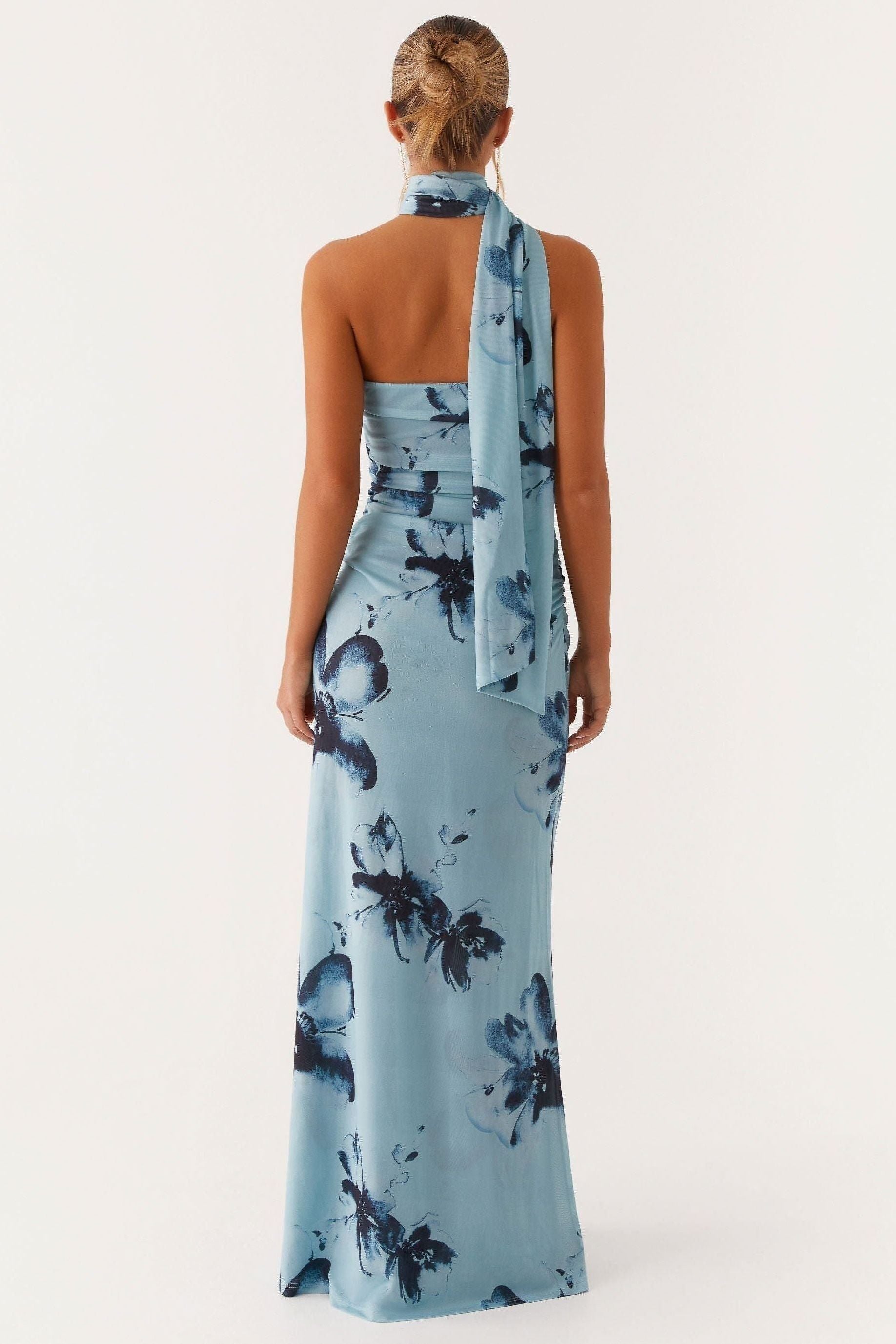Rear view of light blue maxi dress with dark floral pattern and ruched back detail