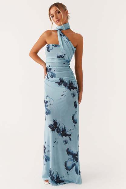 Blue halter maxi dress with navy floral print, ruched waist, and flowing skirt