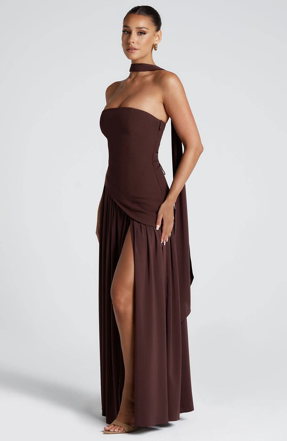 Brown wrap maxi dress side view showing strapless fit and draped asymmetrical hem