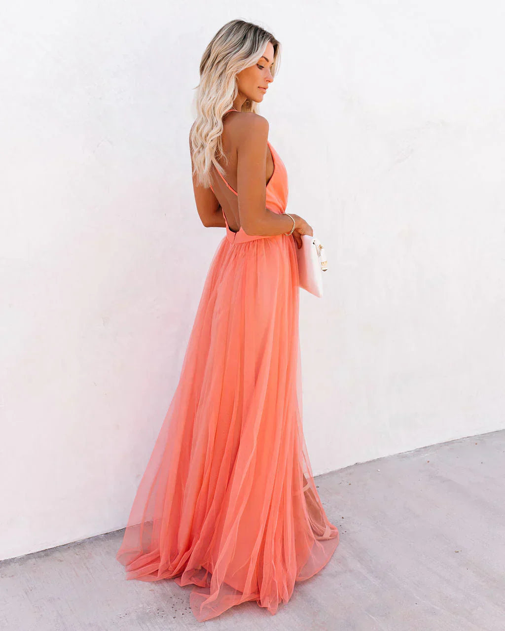 Side view of coral backless maxi dress with thin straps and layered tulle