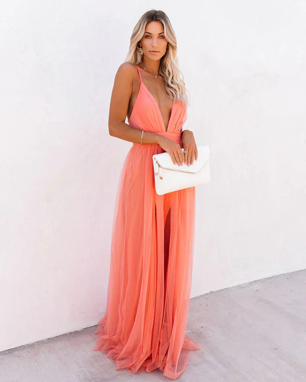 Three-quarter view of coral backless maxi dress with V-neckline and tulle layers