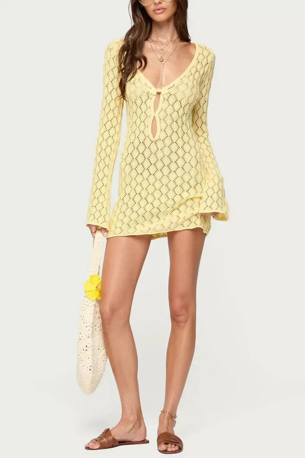 Yellow crochet mini dress with tie closure, flowing sleeves, and matching scarf detail