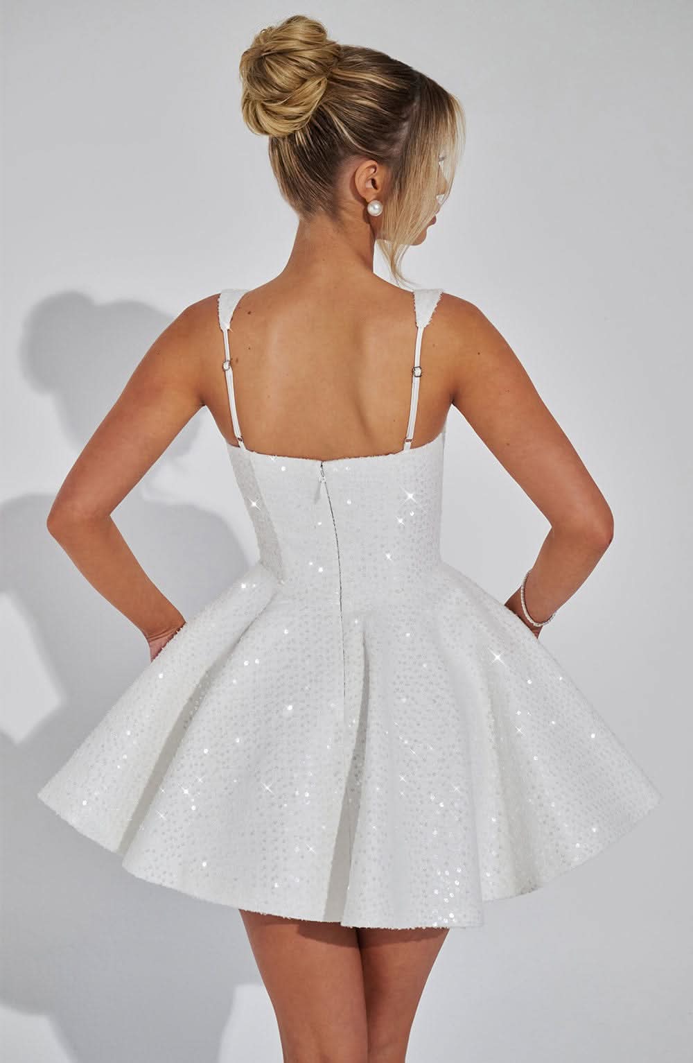 Back view of white sequin dress showing zip and full skirt silhouette