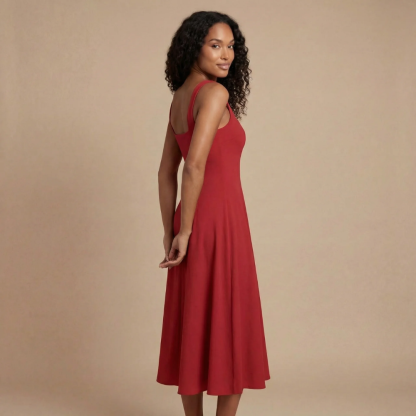 Back view of red midi dress with open back cutout and flowing hemline