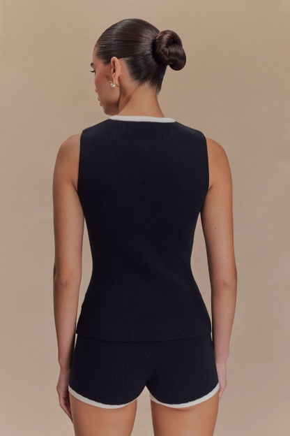 Back view of black ribbed knit tank top with white crew neckline