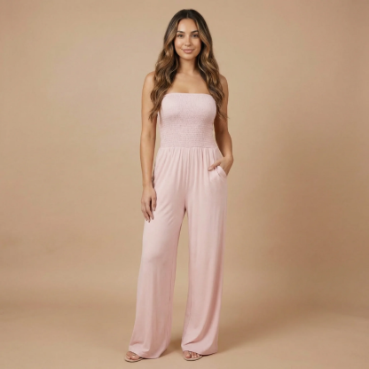 Pale pink strapless smocked jumpsuit with functional pockets and relaxed fit