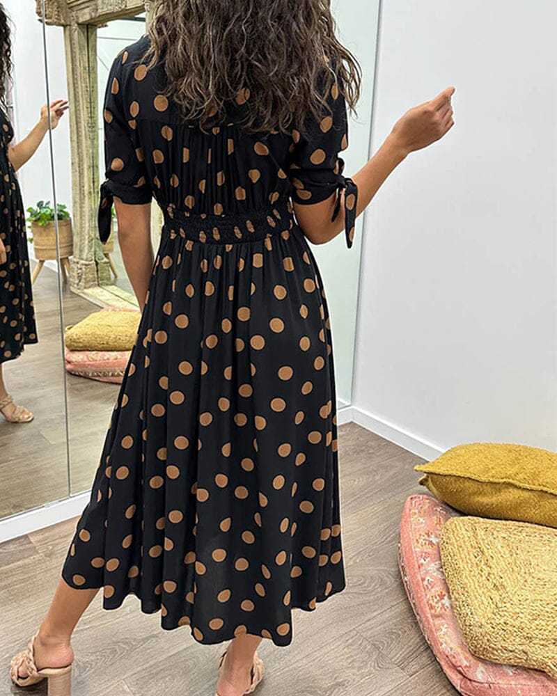 Black wrap midi dress with tan polka dots, back view with tied sleeves