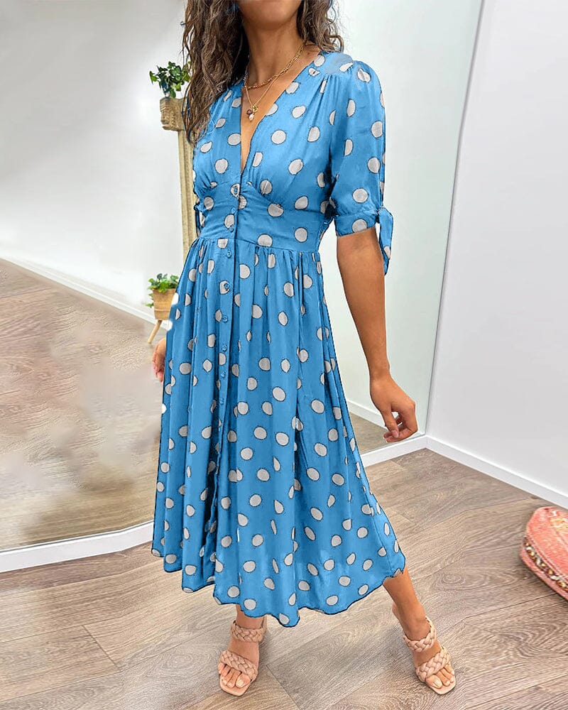 Blue wrap midi dress with white polka dots, front view with three-quarter sleeves