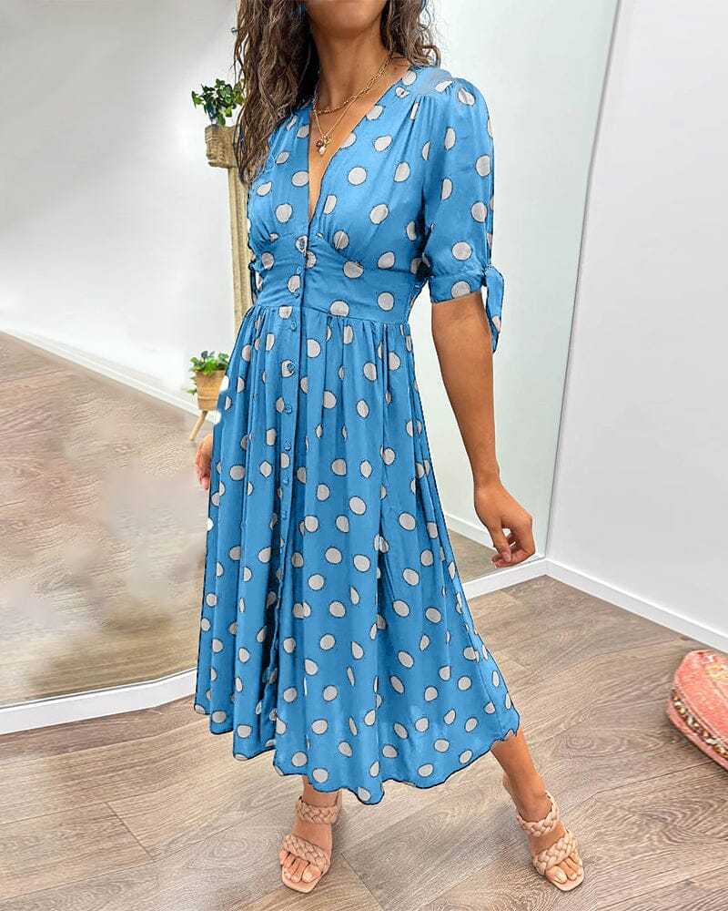 Blue wrap midi dress with white polka dots, front view with three-quarter sleeves