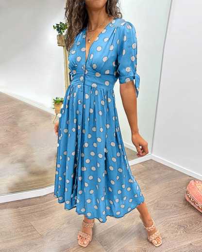 Blue wrap midi dress with white polka dots, front view with three-quarter sleeves