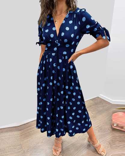 Navy blue wrap midi dress with light blue polka dots, tied sleeves front view