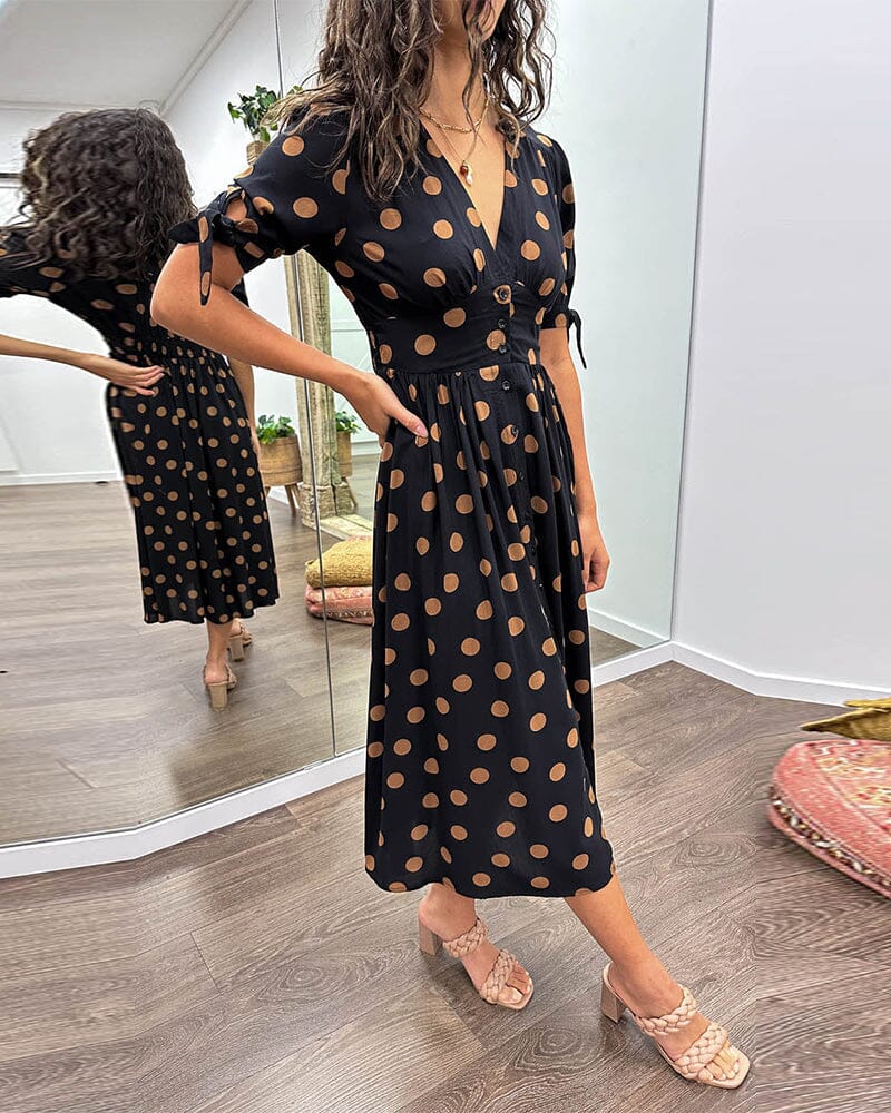 Black wrap midi dress with tan polka dots and tie sleeves