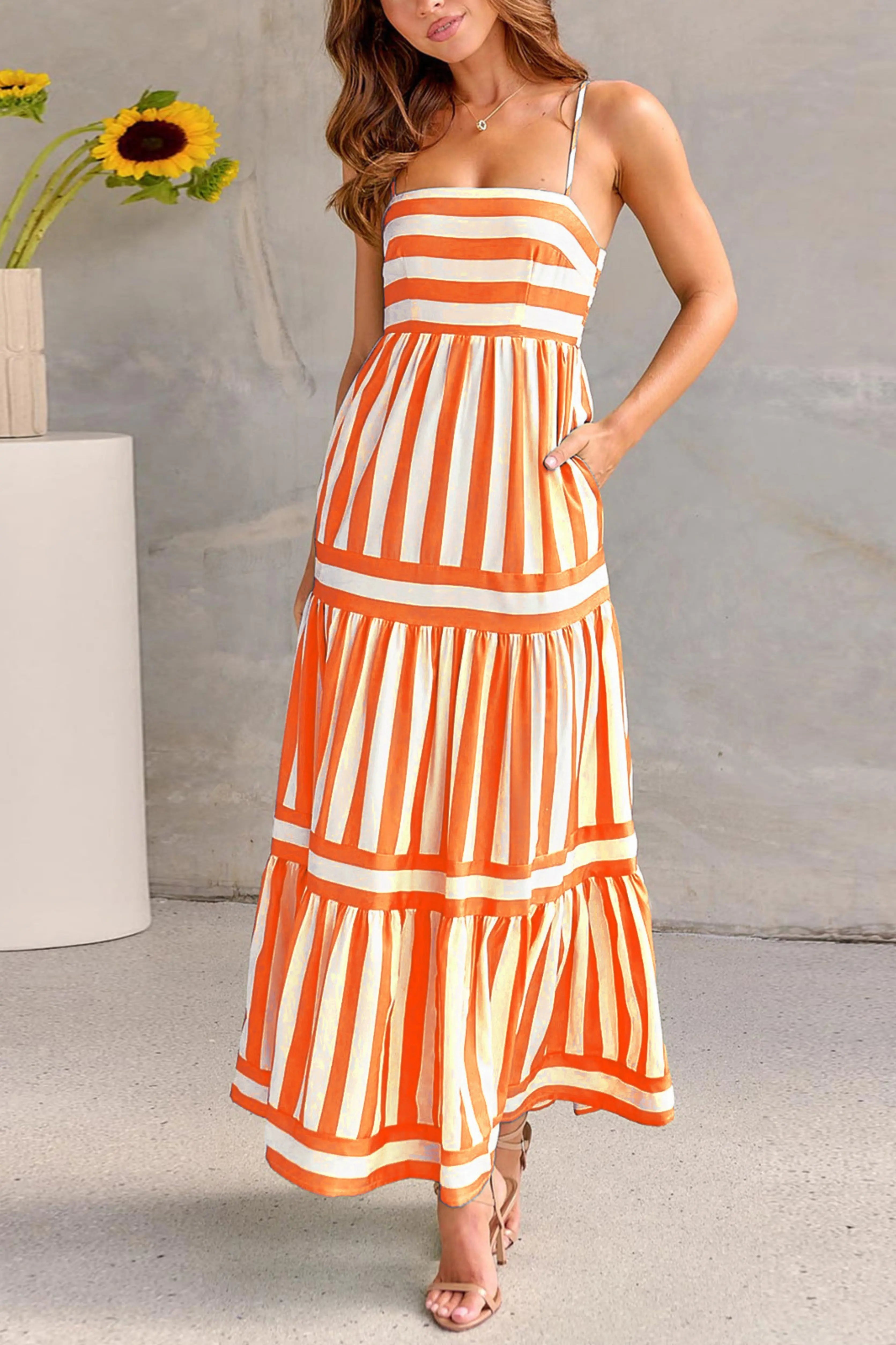 Orange and white striped women's maxi dress with fitted bodice and flowy pleated skirt
