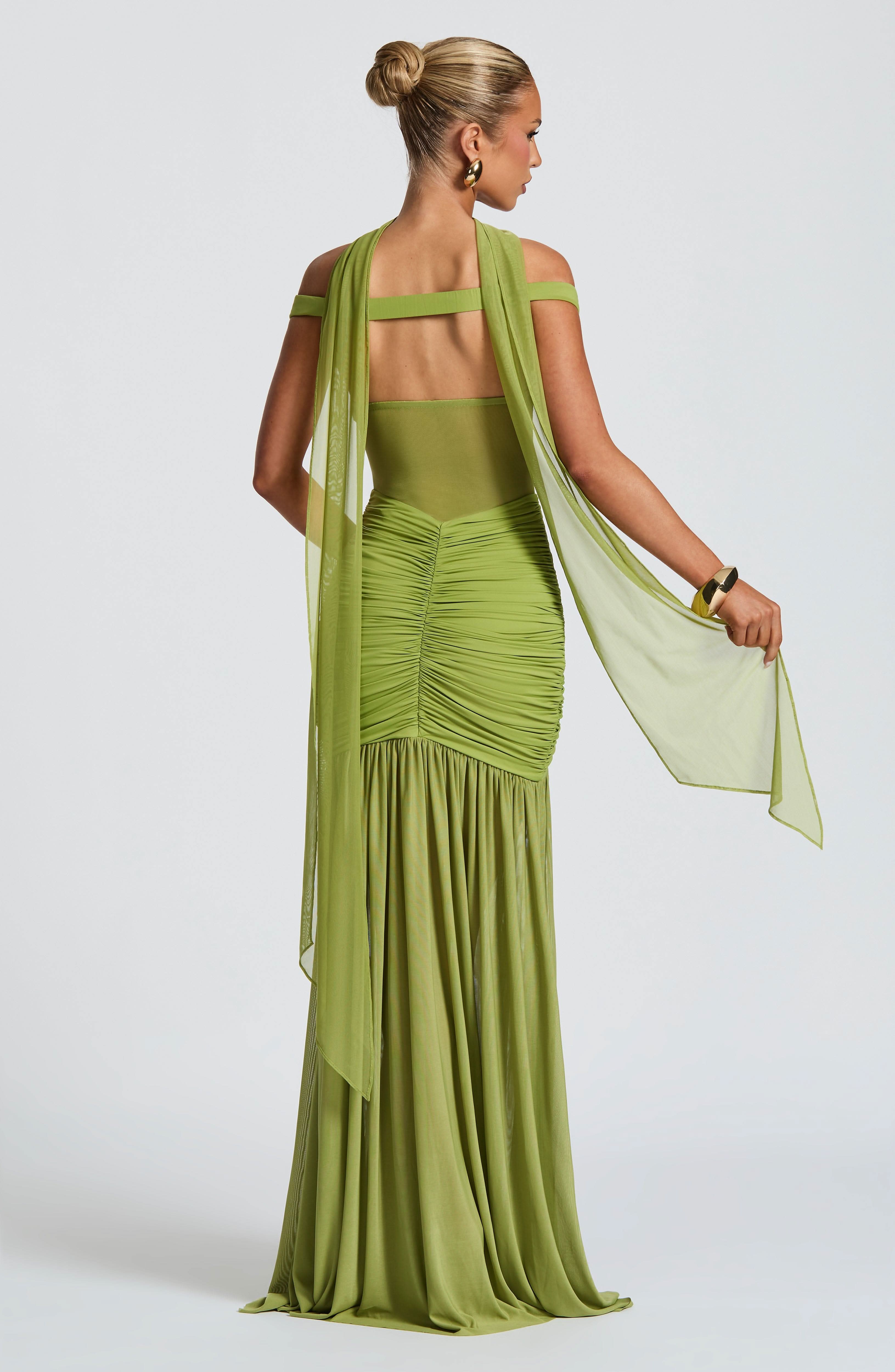 Back view of lime green ruched maxi dress with open back and flowing skirt