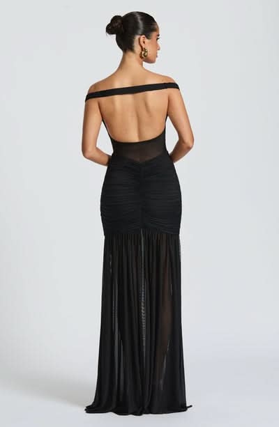 Back view of black ruched maxi dress with open back design