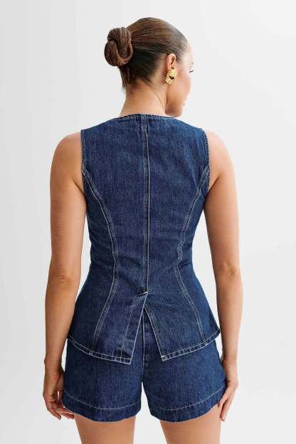 Back view of blue denim vest showing seamed construction and shorts