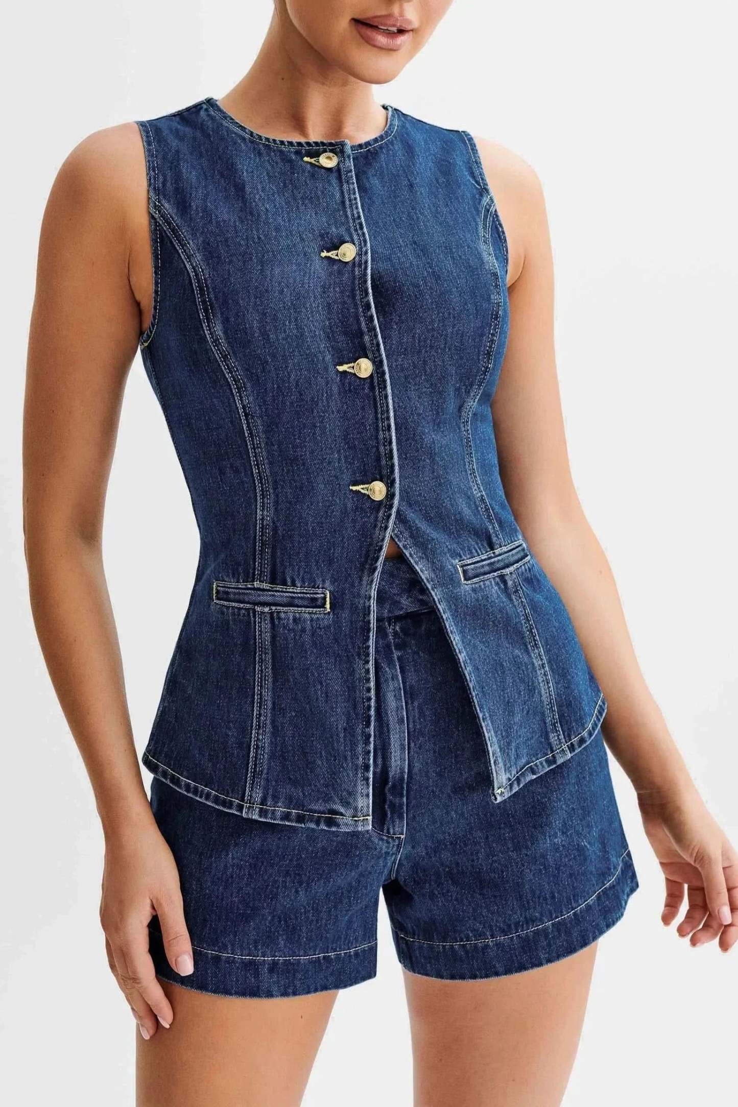Detail view of blue denim vest with peplum hem and gold buttons