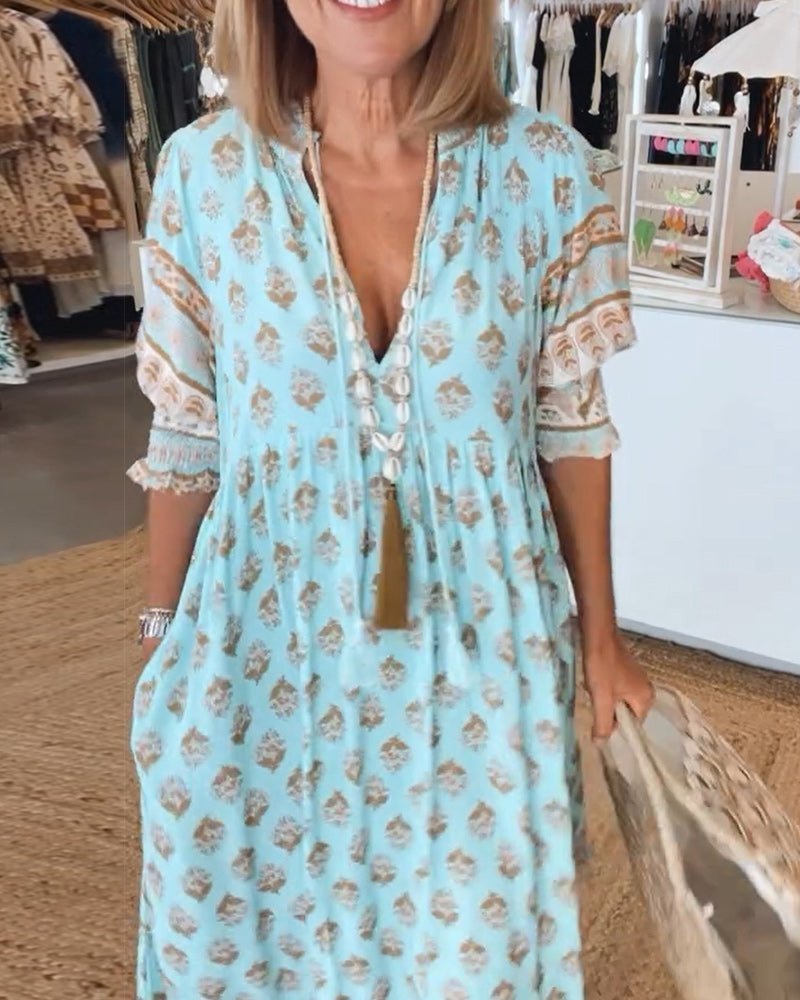 Front close-up of light blue floral tiered dress with V-neckline and tie detail