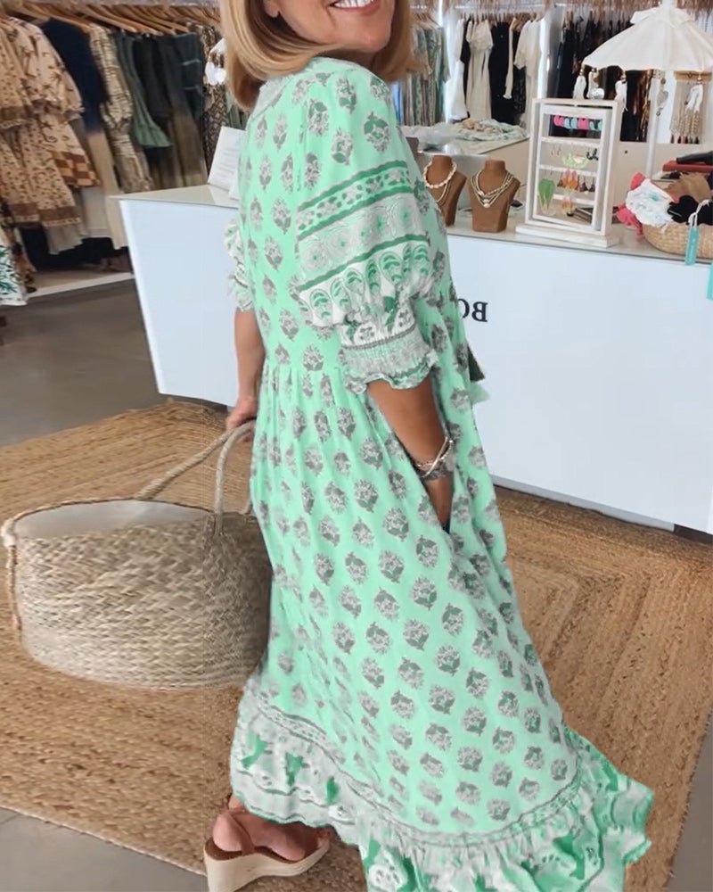 Front close-up of mint green floral tiered dress with V-neckline and tie closure