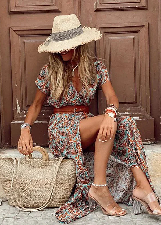 Rust and teal paisley wrap maxi dress with brown belt, high slit, seated pose with accessories