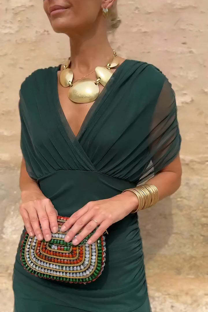 Forest green draped maxi dress close-up showing wrapped bodice and V-neckline