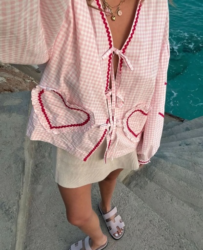 Pink gingham top with heart-shaped ruffle pockets and tie-front neckline