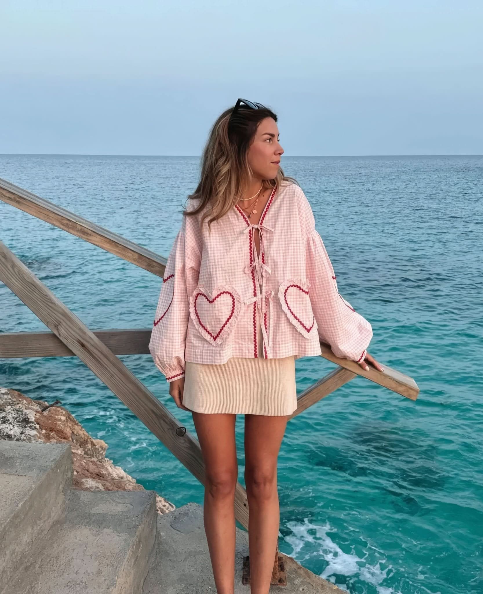 Pink and white checkered ruffle top with heart pockets worn with cream skirt