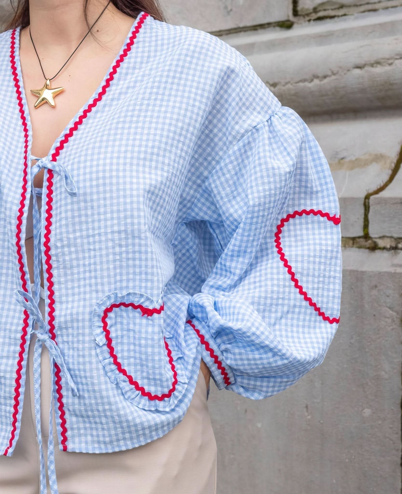 Blue and white checkered blouse with scalloped heart pockets and puffed sleeves