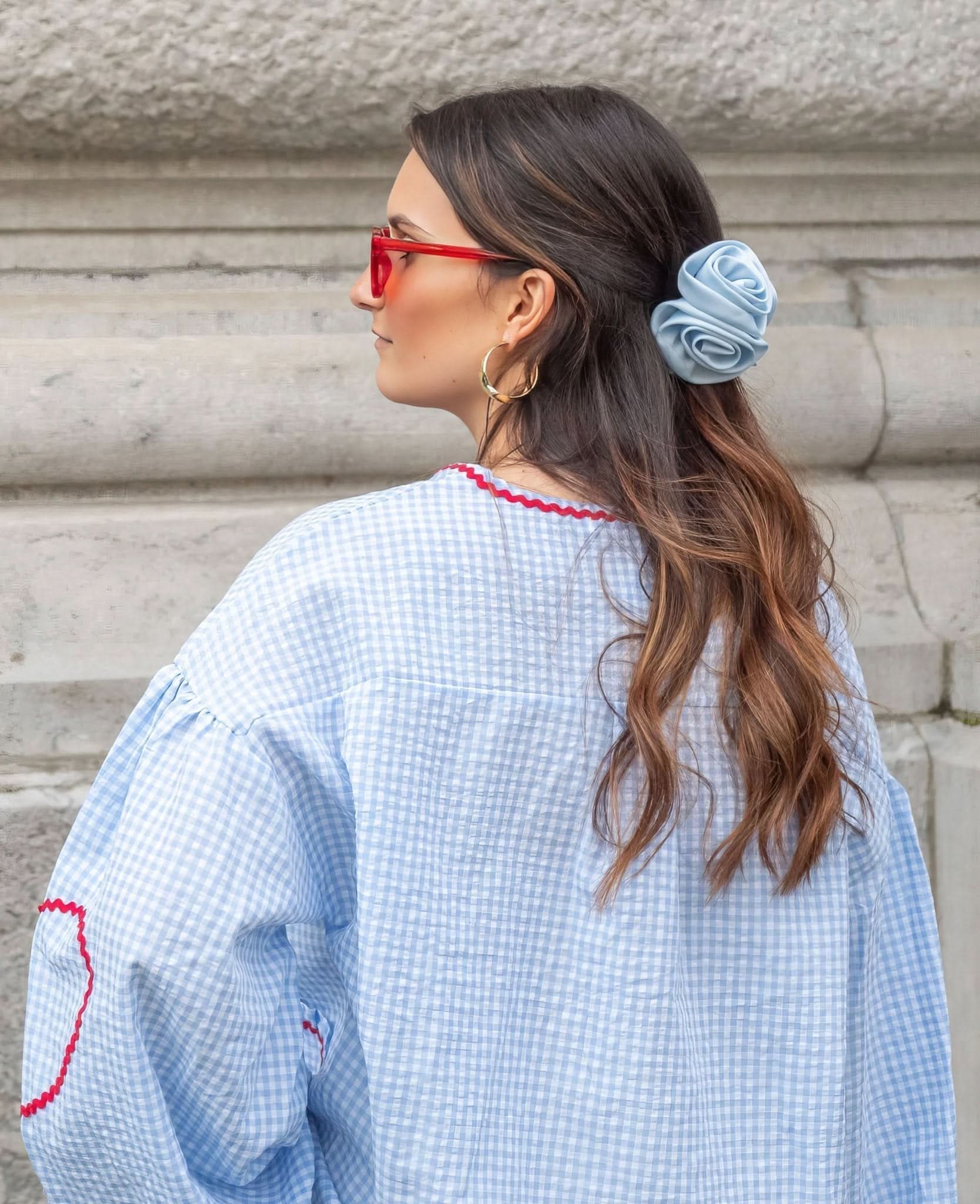 Light blue gingham top with red ruffle heart pocket detail shown from back