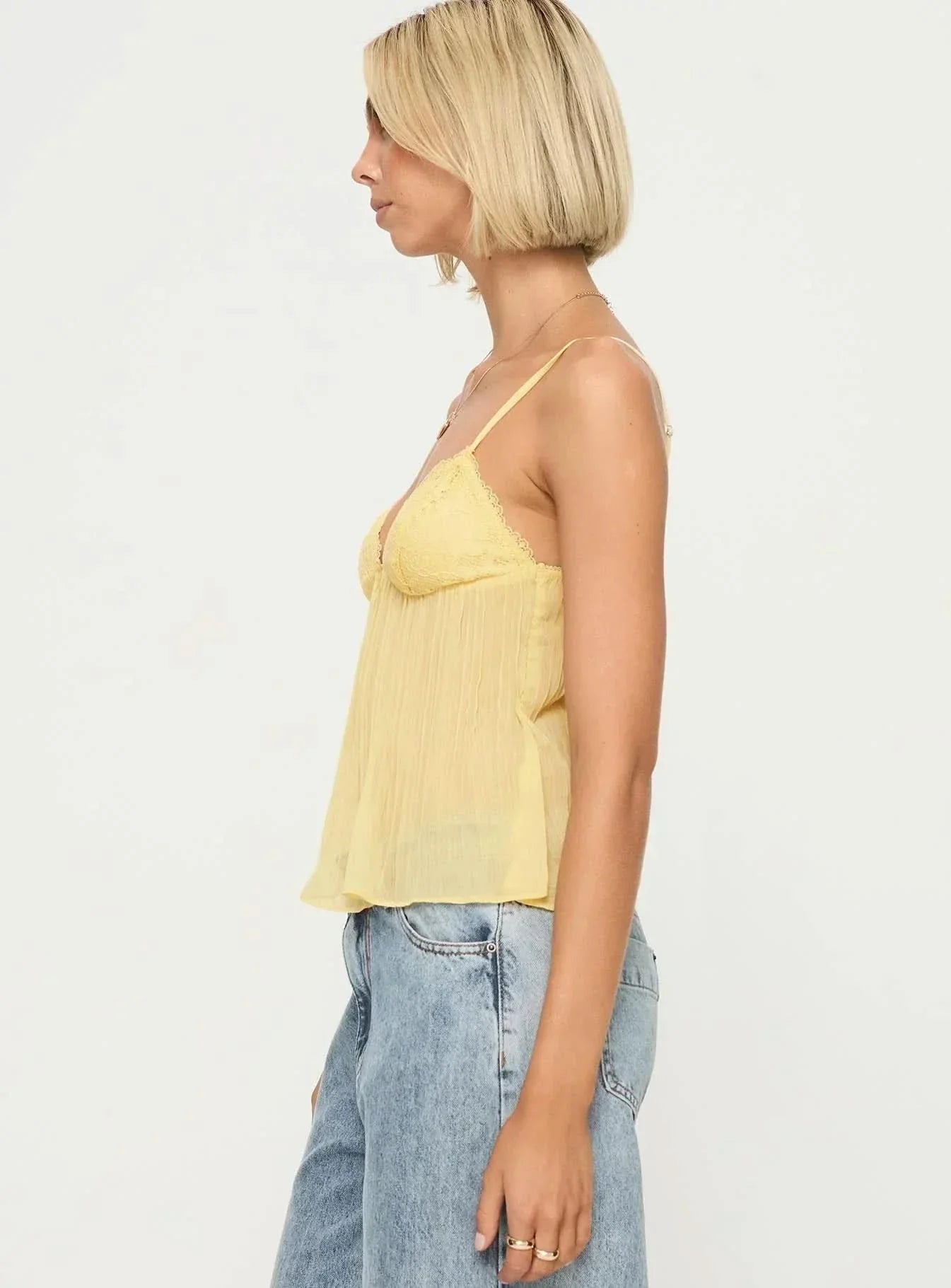 Side profile of pale yellow pleated cami with lace bust